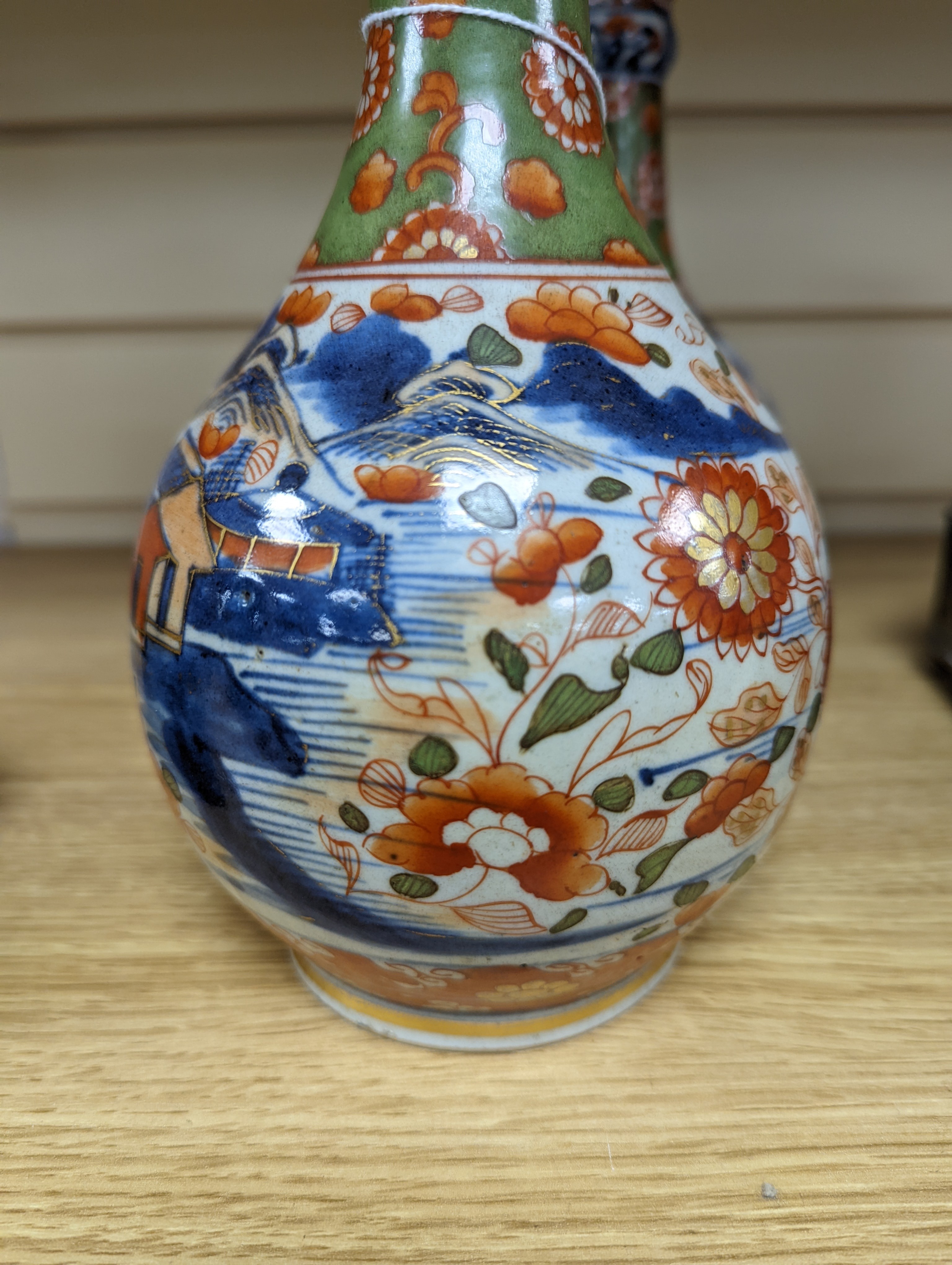 A pair of 18th century Chinese clobbered blue and white bottle vases 23cm